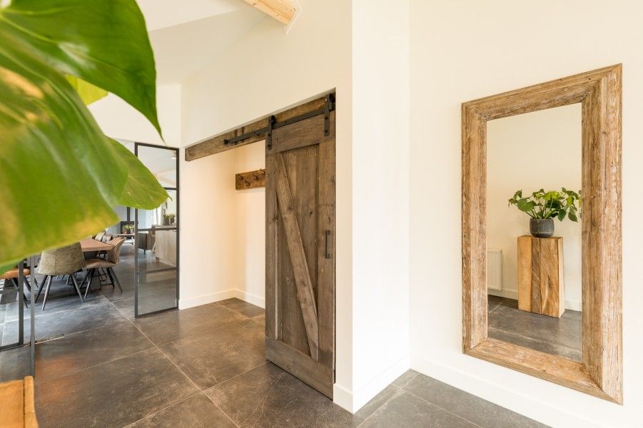 Innenraum mit Holzschiebetuer und Spiegel im Bungalow Wagenschuur, Hollum, Ameland, Watteninseln.