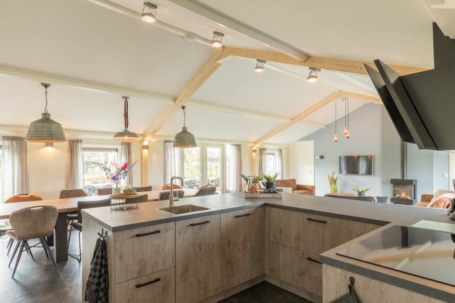 Offene Kueche im Ferienhaus Wagenschuur, Hollum, Ameland mit modernen Geraeten und Blick auf die Watteninseln.