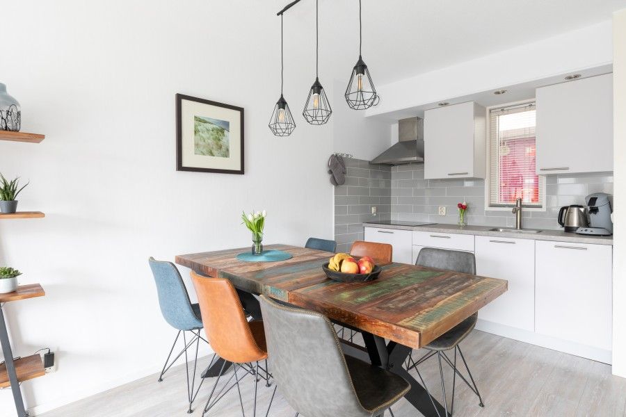 Gemuetliche Essecke in Amelander Kaap 126, Ferienwohnung in Hollum, Ameland, mit moderner Kueche und stilvollem Esstisch.