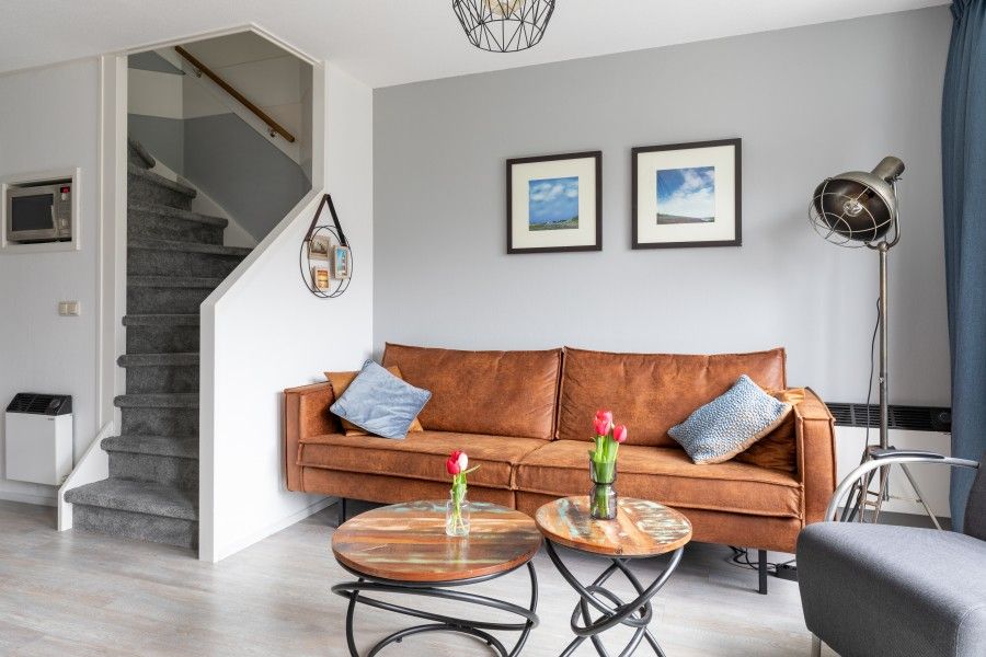 Komfortables Wohnzimmer des Amelander Kaap 126 in Hollum, Ameland, mit gemuetlichem Sofa und moderner Einrichtung.