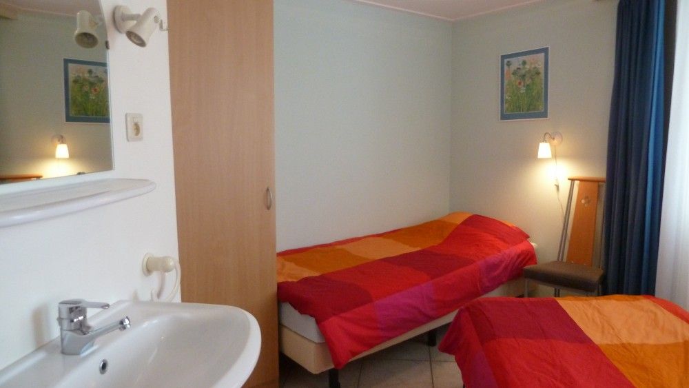 Komfortables Schlafzimmer im Fairway-Bungalow, Hollum, Ameland, mit farbenfroher Einrichtung auf den Watteninseln.