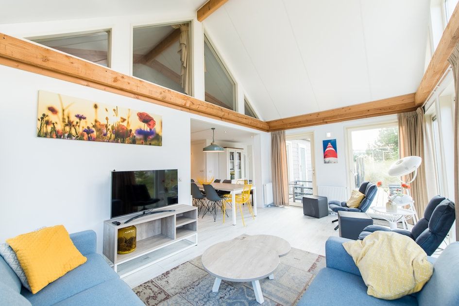 Geraeumiges Wohnzimmer der Waddenlodge 6+2 in Hollum, Ameland mit moderner Einrichtung und viel Tageslicht, ideales Ferienhaus auf den Watteninseln.