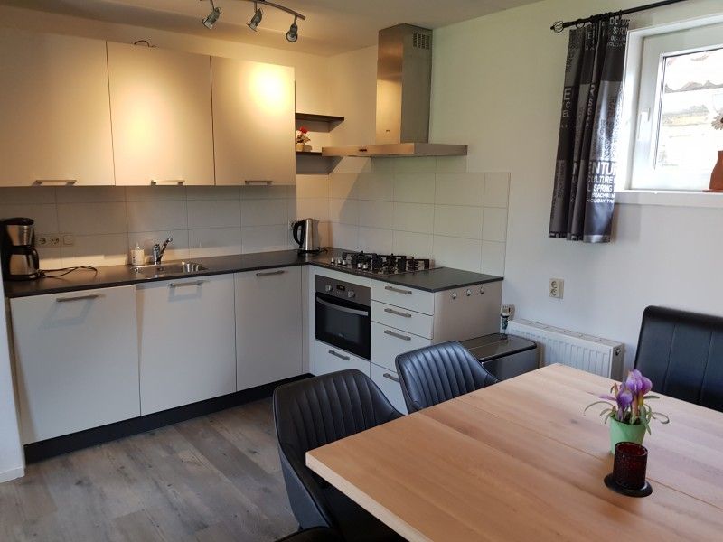 Moderne Kueche im Ferienhaus Piggelmee, Hollum, Ameland, mit Essecke und Geraeten.