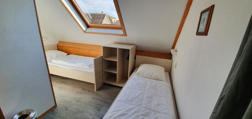 Gemuetliches Schlafzimmer mit Dachfenster im Ferienhaus Piggelmee, Hollum, Ameland.