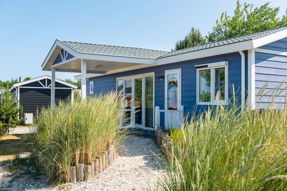 Duinchalet 4 in Hollum, Ameland biedt een charmant vakantiehuis met veranda, omgeven door groene natuur op de Waddeneilanden.