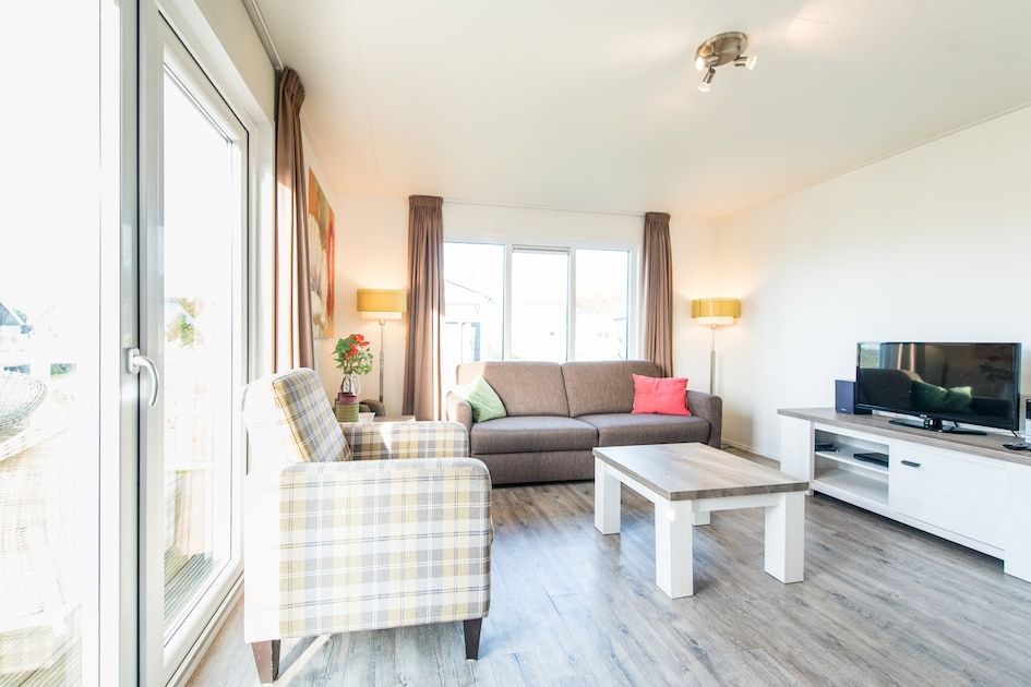 Gezellige woonkamer in Duinchalet 4, vakantiehuis in Hollum, Ameland, met comfortabele zithoek en veel natuurlijk licht.
