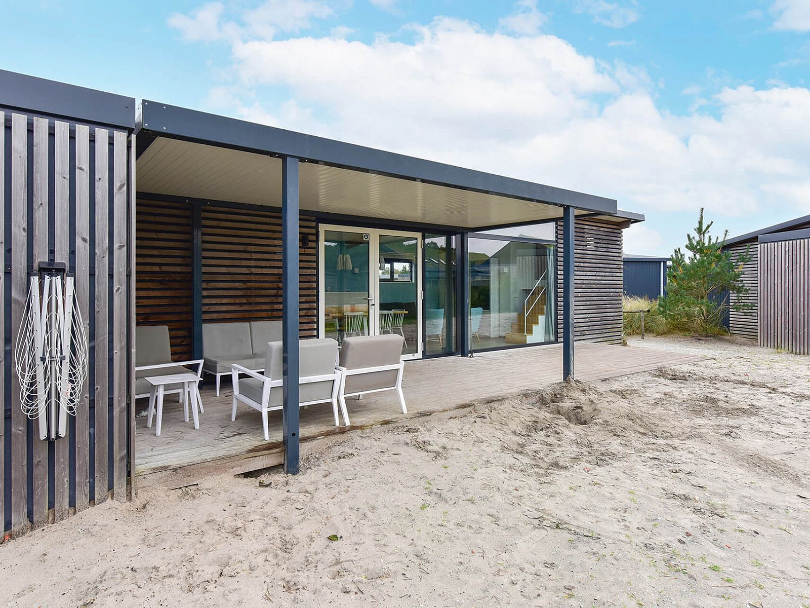 Terras van vakantiehuis Vrijstaande woning in Hollum op Ameland, omgeven door zand en groen.