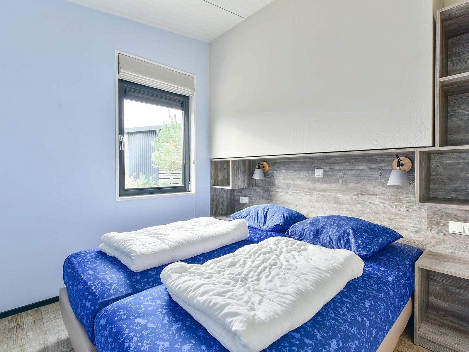 Comfortabele slaapkamer in Vrijstaande woning in Hollum, Ameland, met uitzicht op de tuin.