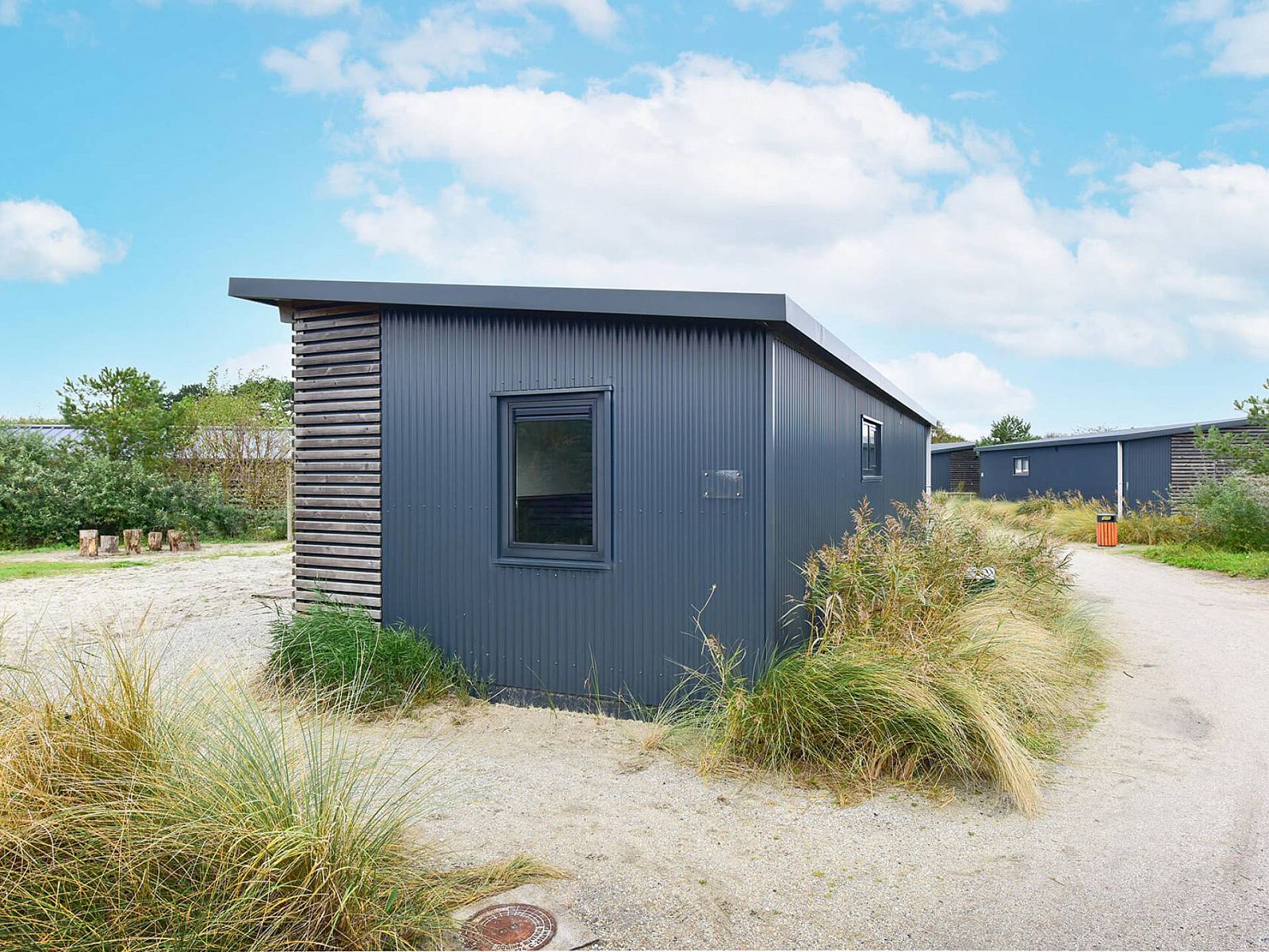 Buitenkant van Vrijstaande woning in Hollum, Ameland, omgeven door duinen.