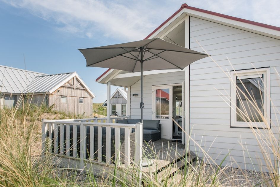 Geniet van de zon op het terras van Eilandlodge 4, een gezellig vakantiehuis in Hollum, Ameland, te midden van de prachtige natuur van de Waddeneilanden.