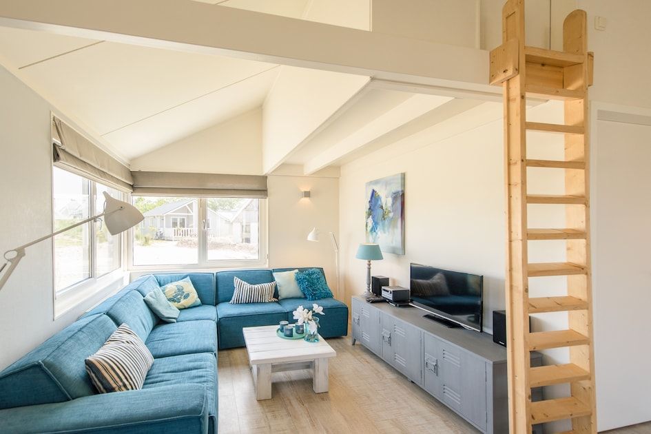Gezellige woonkamer in Eilandlodge 4, een vakantiehuis in Hollum, Ameland, met comfortabele zithoek en moderne inrichting.