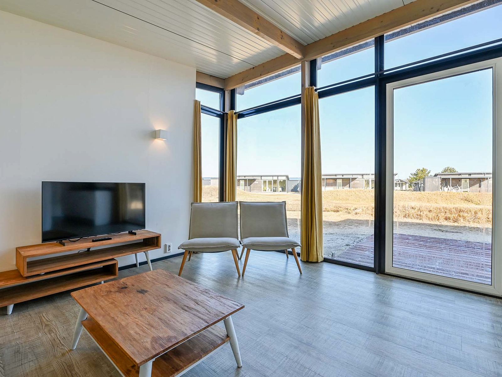 Helles Wohnzimmer eines freistehenden Hauses in Hollum, Ameland, Ferienhaus mit groen Fenstern auf den Watteninseln.