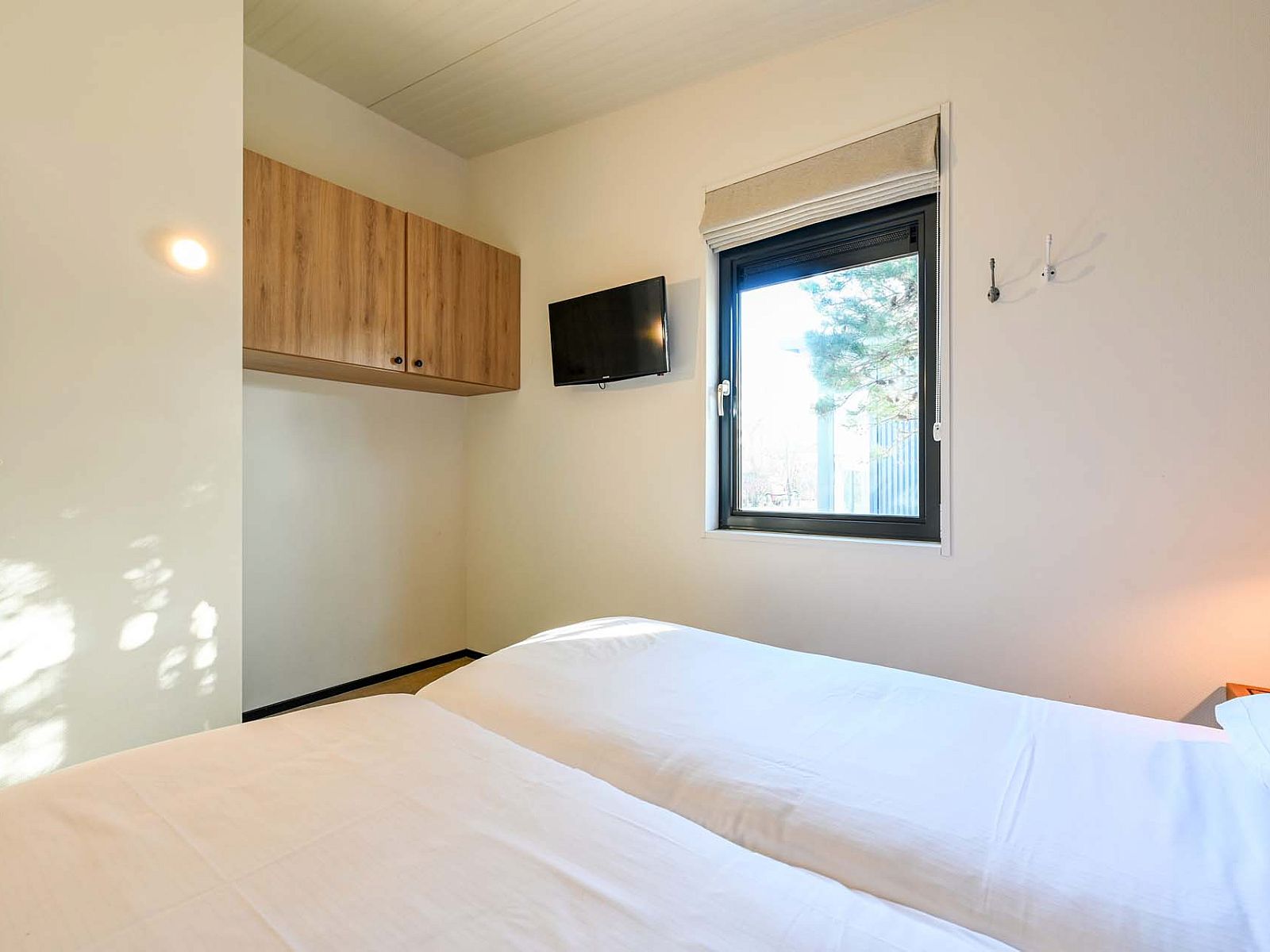 Schlafzimmer mit TV in freistehendem Haus in Hollum, Ameland, Ferienhaus auf den Watteninseln.