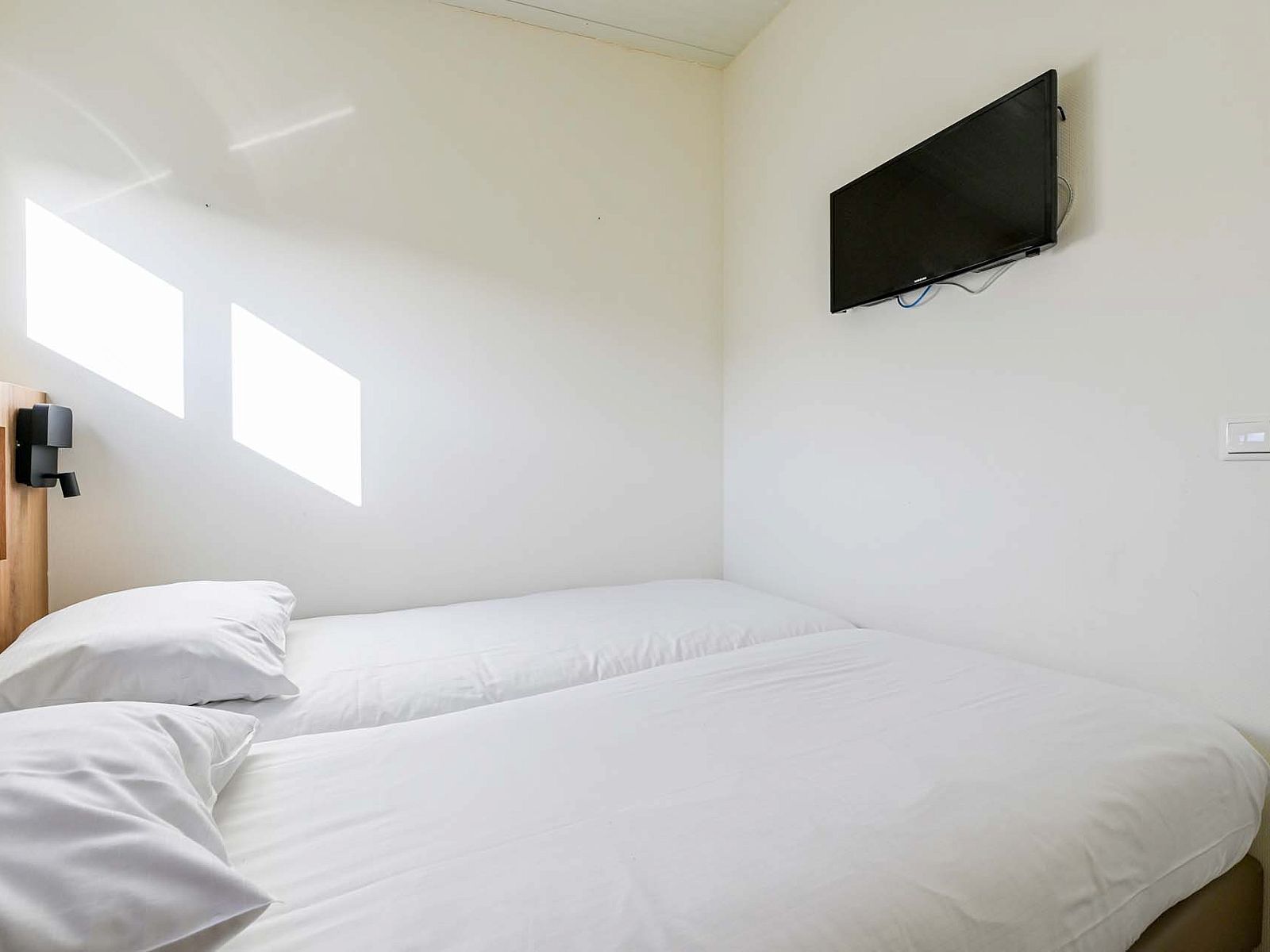 Helles Schlafzimmer mit TV in freistehendem Haus in Hollum, Ameland, Ferienhaus auf den Watteninseln.