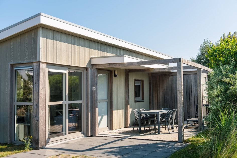Amelandlodge 4 in Hollum, Ameland biedt een serene vakantie-ervaring met een zonnig terras en moderne vakantiehuisfaciliteiten.