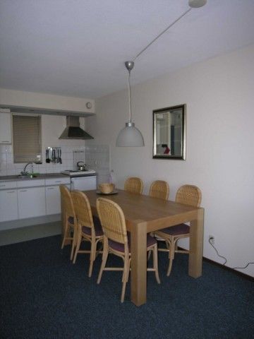 Gezellige eetruimte in Amelander Kaap nr. 54, een appartement in Hollum, Ameland, Waddeneilanden, met moderne keukenfaciliteiten.