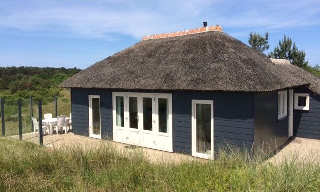 Parnassia Bungalow in Nes, Ameland mit Reetdach und Terrasse inmitten der Natur.