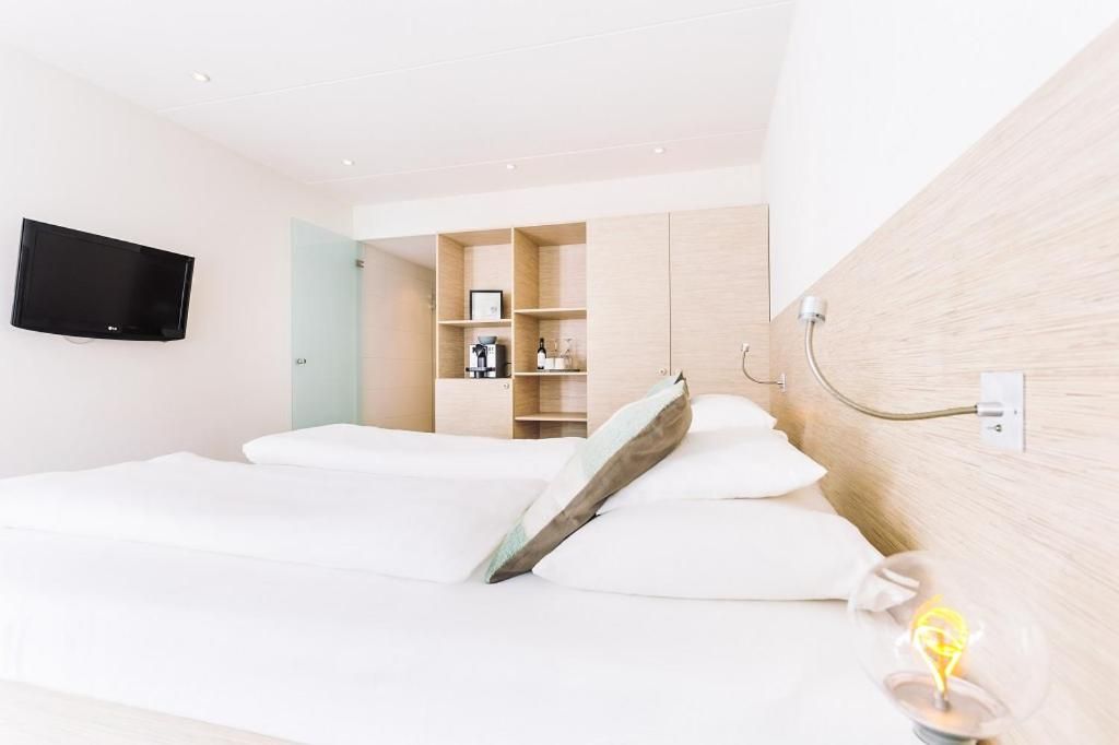 Helles Schlafzimmer mit Flachbildschirm in Logement Zee van Tijd, Nes, Ameland.