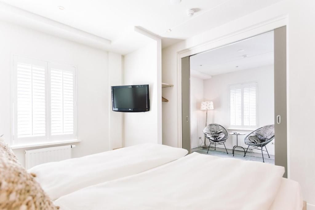 Schlafzimmer mit Schiebetueren zum Wohnbereich in Logement Zee van Tijd, Nes, Ameland.