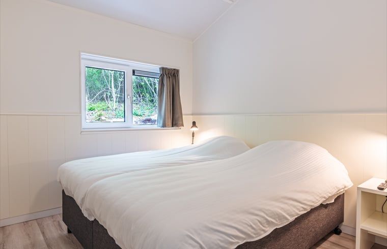 Komfortables Schlafzimmer im Ferienhaus in Nes, Ameland, fuer eine erholsame Nachtruhe auf den Watteninseln.