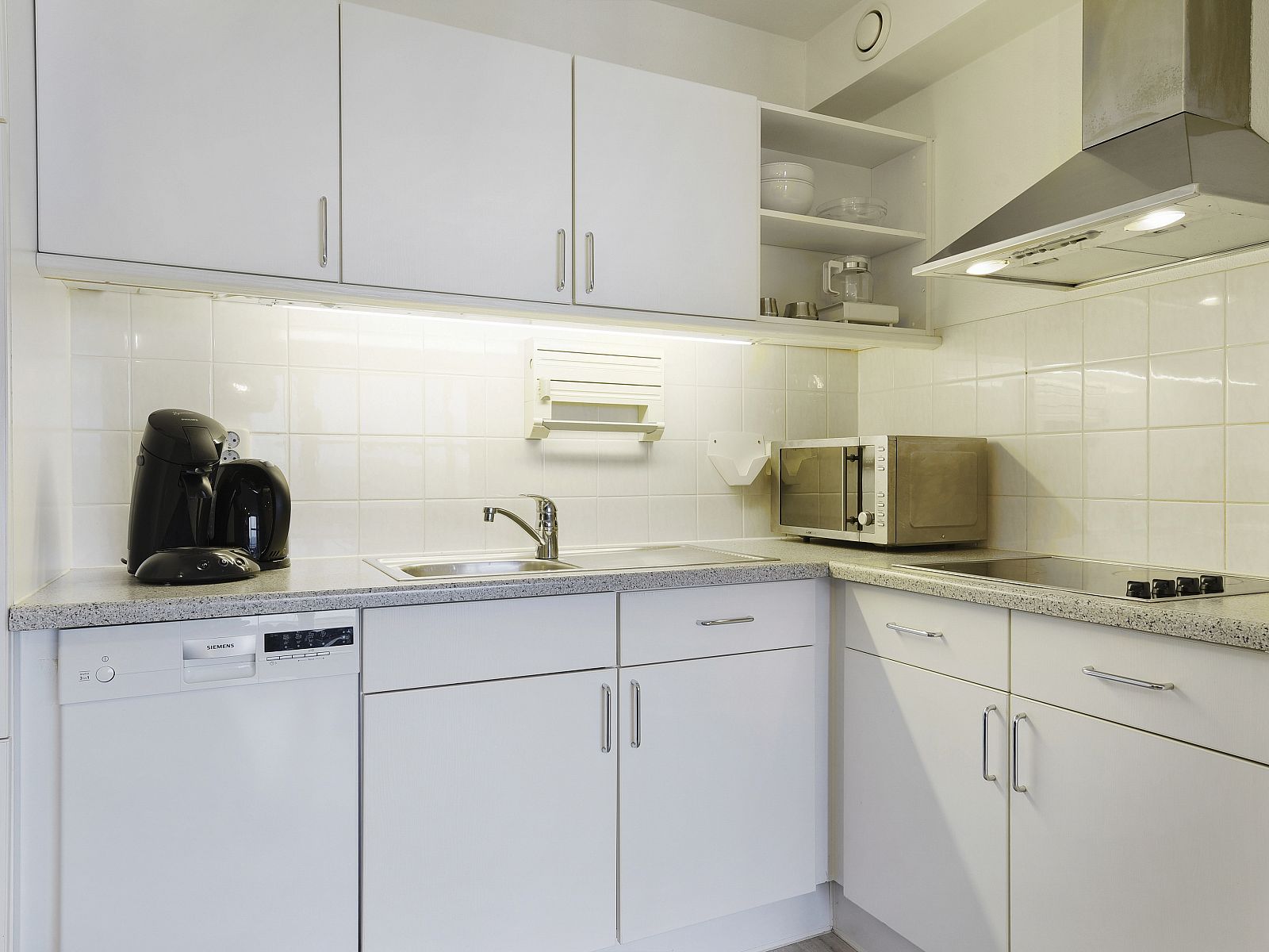 Cozy dining area in Ameland State apartment, Nes, Ameland, with crockery and fruit basket.