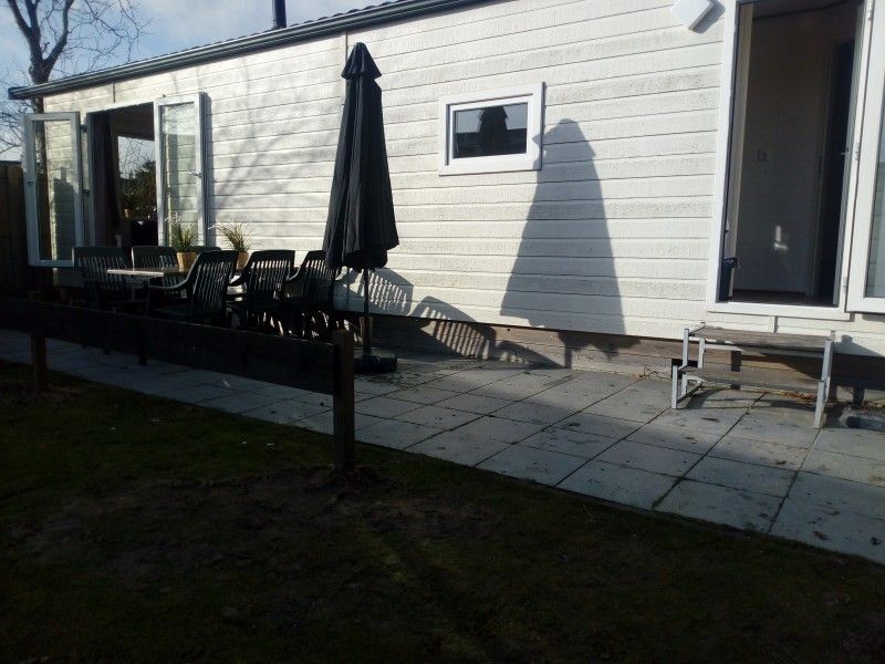 Zonnig terras van chalet Protter in Buren, Ameland, ideaal voor buiten dineren en ontspanning.