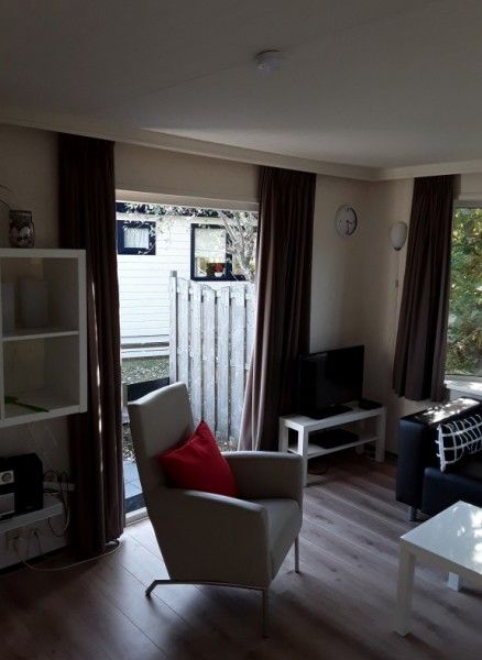 Gezellige woonkamer in chalet Protter in Buren, Ameland, met comfortabele zitplaatsen en veel natuurlijk licht.