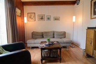 Gemtliches Wohnzimmer des Ferienhauses Huisje Schier auf Schiermonnikoog, Watteninseln, mit bequemer Sitzecke.