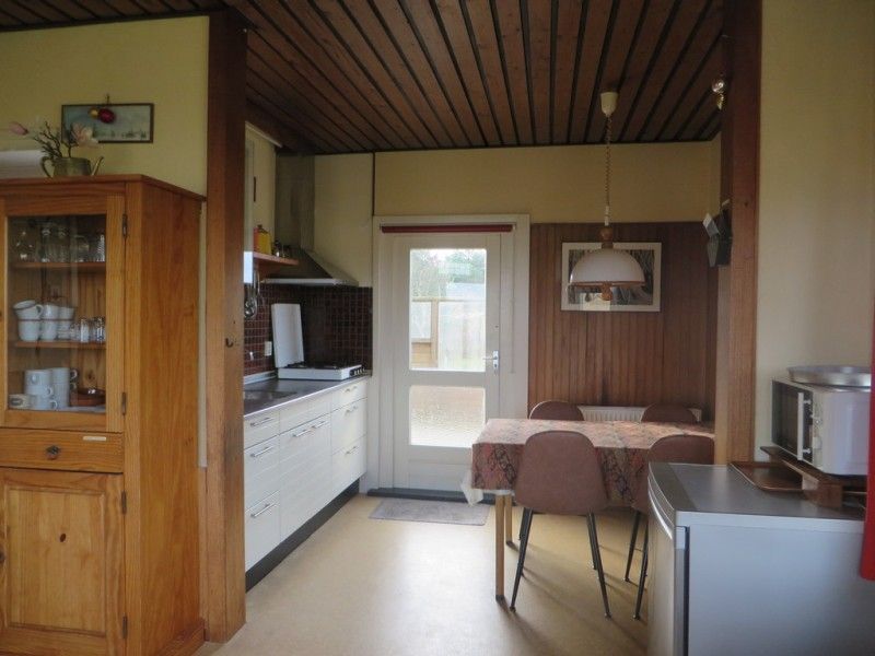 Gemuetliche Kueche des Ferienhauses Zeerust auf Schiermonnikoog, Watteninseln, mit Holzinterieur und Essecke fuer einen entspannten Aufenthalt.