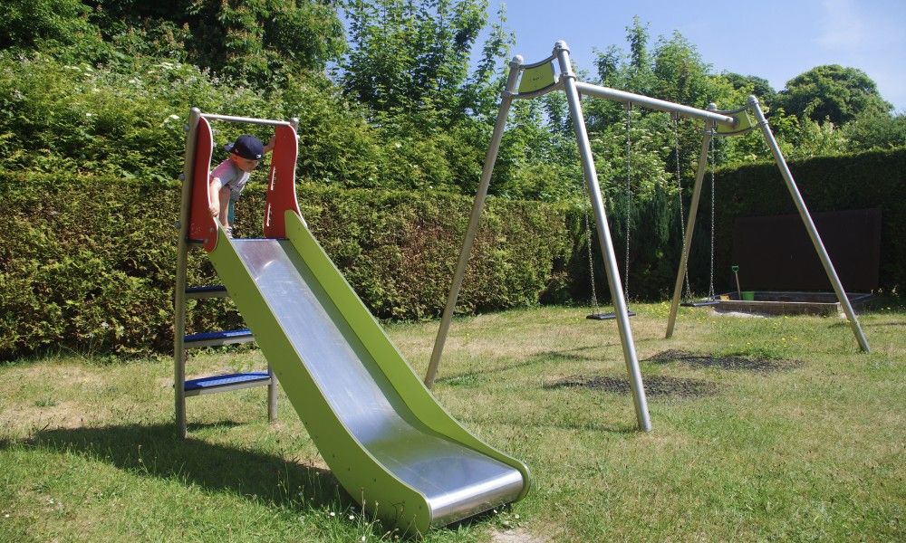 Glijbaan en schommel in de tuin van Klaver Vier vakantiehuis op Schiermonnikoog.