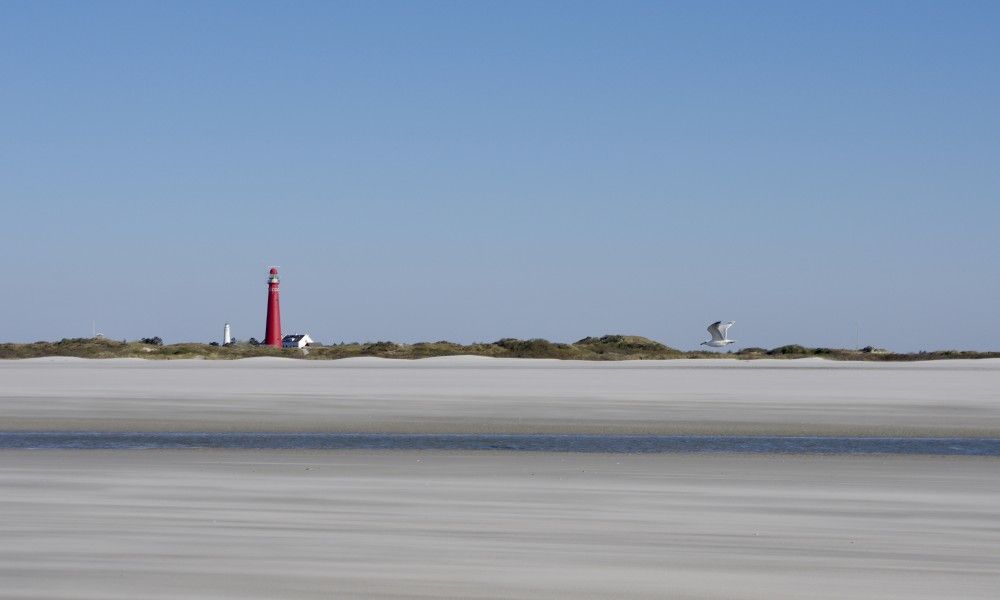 Uitzicht op de vuurtoren van Schiermonnikoog vanaf het strand, nabij Klaver Vier.