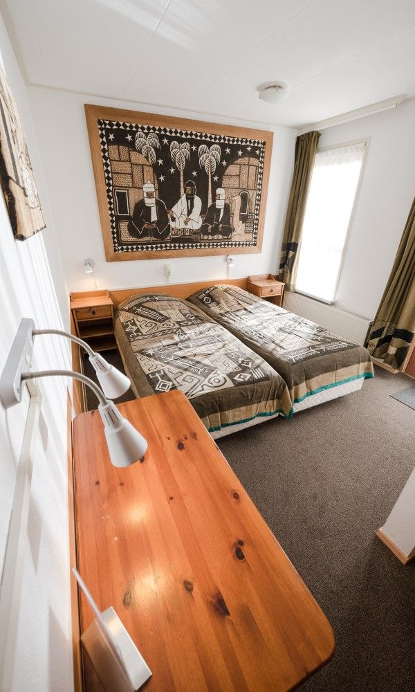 Stilvolle Schlafzimmergestaltung in der Pension Westerburen, Bed and Breakfast auf Schiermonnikoog, mit einzigartigem Wanddekor.