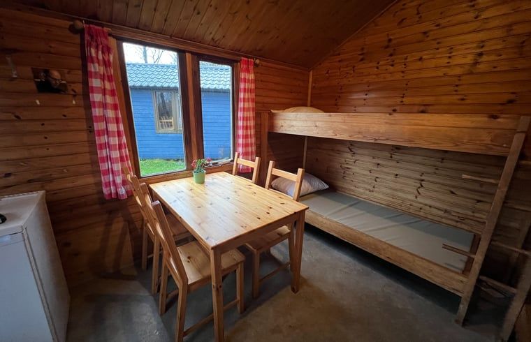 Cozy interior of Holiday Home in Workum with wooden interior, bunk bed and dining area, ideal for a stay at the IJsselmeer.