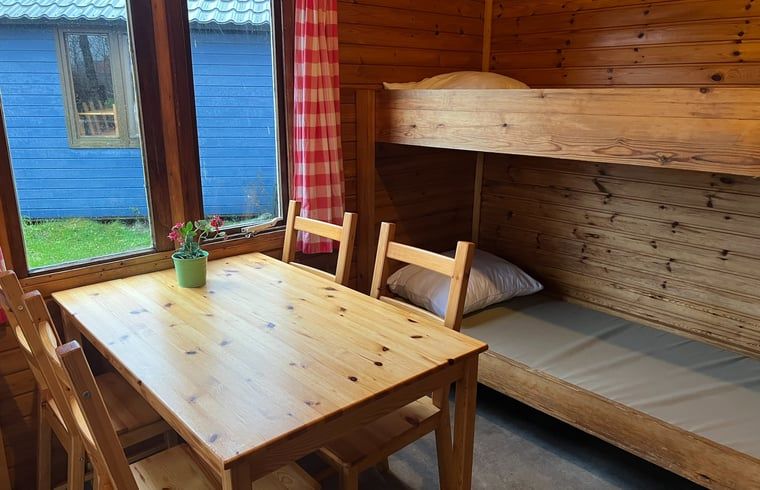 Cozy interior of Holiday Home in Workum with wooden interior, bunk bed and garden view in the Frisian lake region.