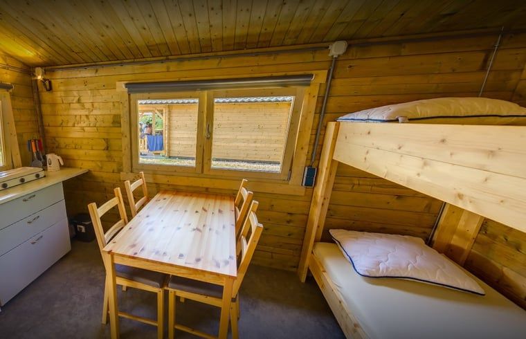 Cozy interior of Holiday home in Workum with wooden interior, bunk bed and dining table, near the IJsselmeer and Frisian lakes.