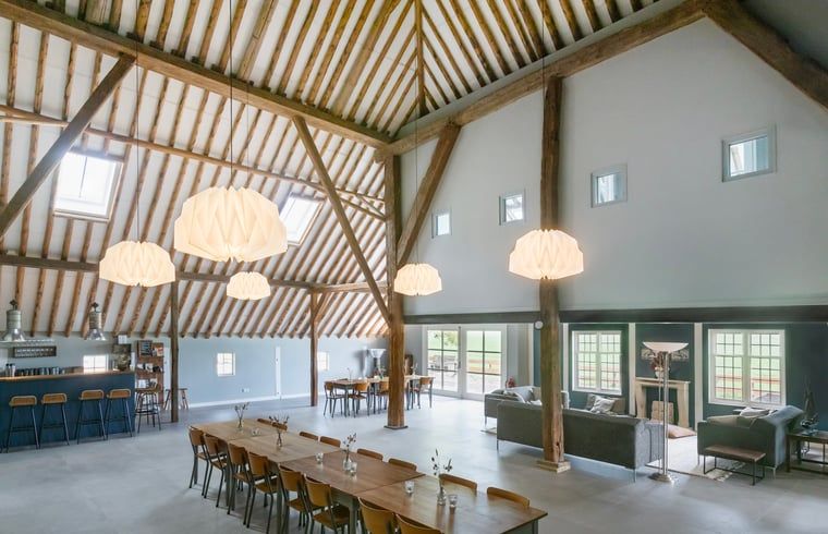 Buitenkant van Vakantiehuisje in Piaam omgeven door groene natuur en bomen, ideaal voor een ontspannen verblijf aan de Friese meren.