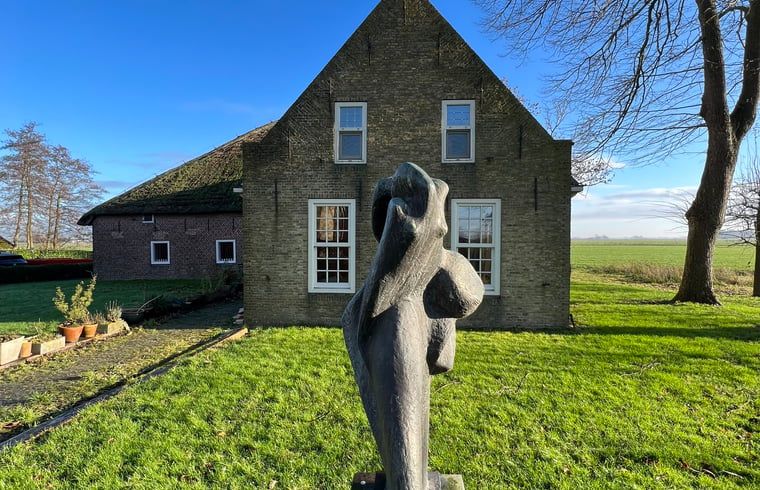 Kunstzinnig beeldhouwwerk bij Vakantiehuisje in Piaam, met uitzicht op weidse velden en het IJsselmeer.