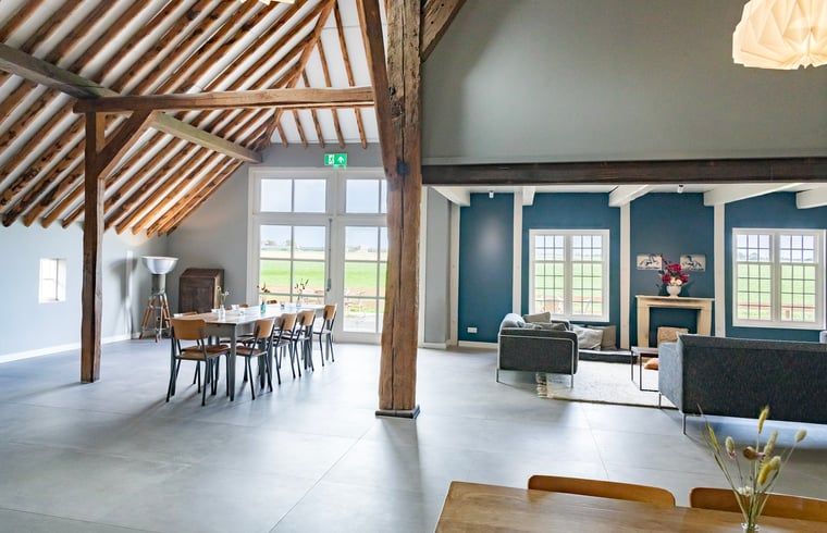 Open leefruimte in Vakantiehuisje in Piaam met uitzicht op groene velden, perfect voor een rustige vakantie aan het IJsselmeer.