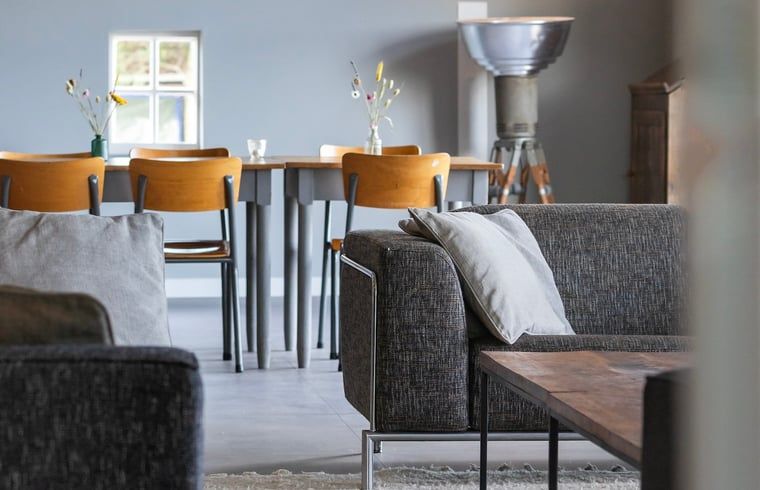 Comfortabele zithoek in Vakantiehuisje in Piaam met zicht op de eetkamer, ideaal voor familiebijeenkomsten aan het IJsselmeer.