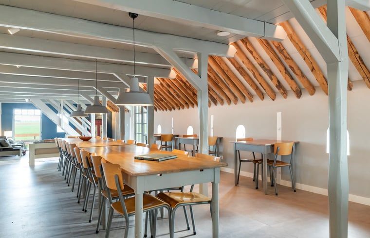 Eetruimte op de bovenverdieping van Vakantiehuisje in Piaam met moderne verlichting, ideaal voor gezellige avonden aan het IJsselmeer.