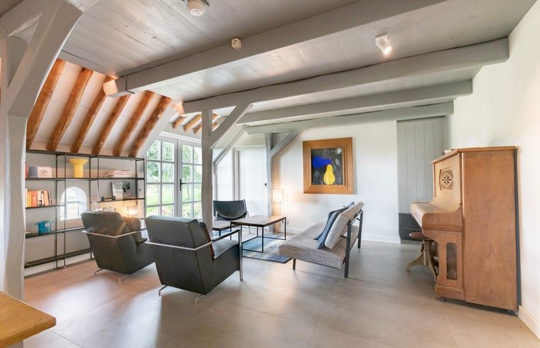 Knusse zithoek in Vakantiehuisje in Piaam met uitzicht op de tuin, ideaal voor een ontspannen verblijf aan het IJsselmeer.