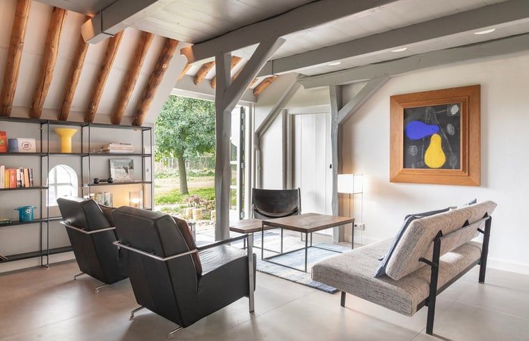 Gezellige leeshoek in Vakantiehuisje in Piaam met comfortabele zitplaatsen, perfect voor een rustige middag aan de Friese meren.