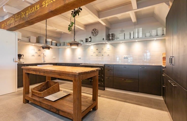 Ruime keuken in Vakantiehuisje in Piaam met houten werkblad en moderne apparatuur, ideaal voor kookliefhebbers aan het IJsselmeer.