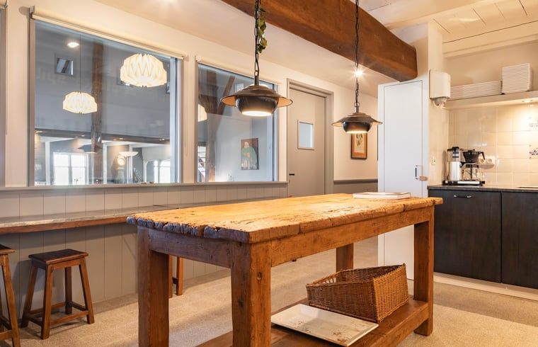 Gezellige keukenhoek in Vakantiehuisje in Piaam met houten details en moderne verlichting, ideaal voor kookplezier aan de Friese meren.