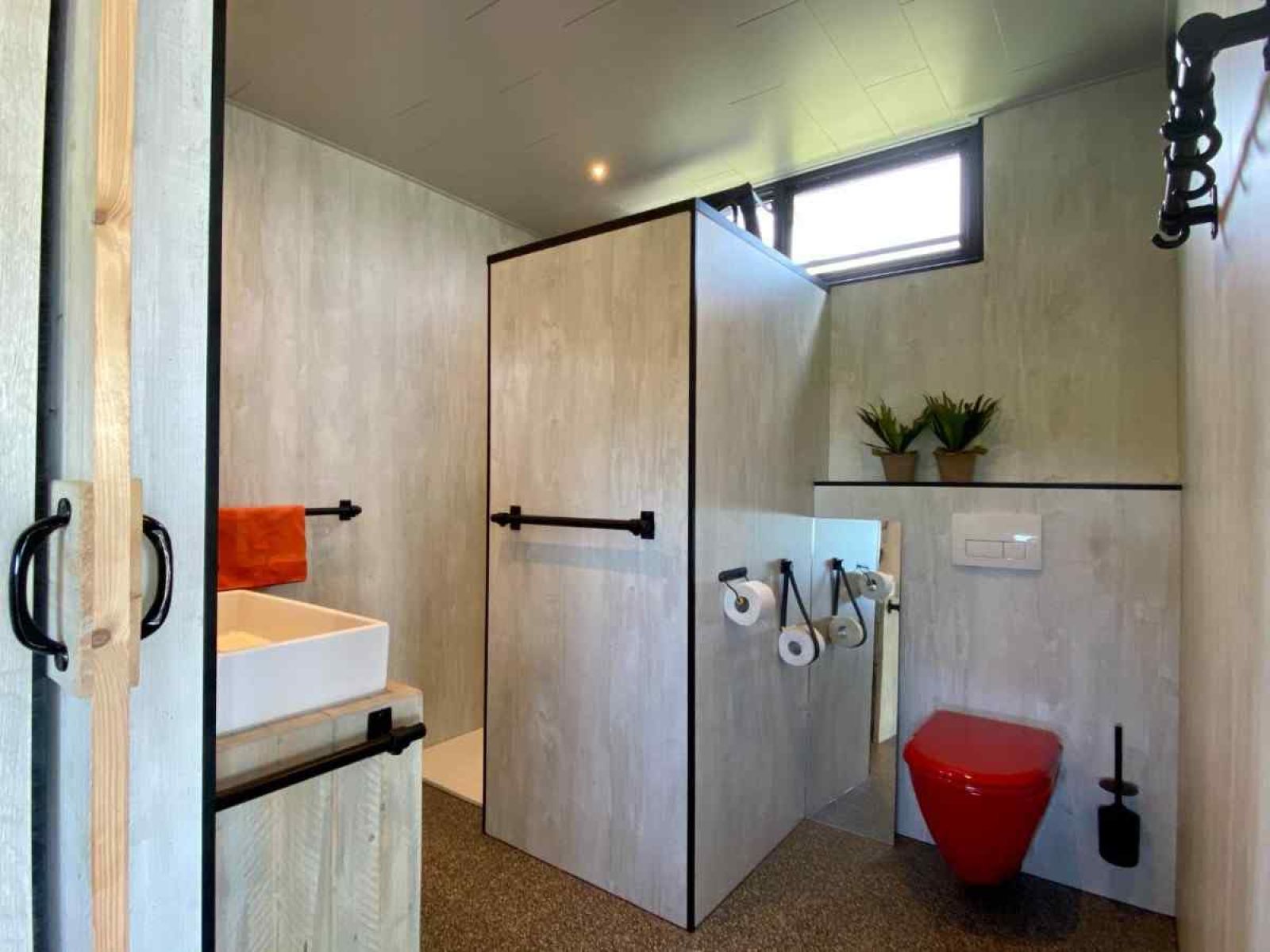 Moderne Kueche im Ferienhaus FR058, Warns, mit rotem SMEG-Kuehlschrank.