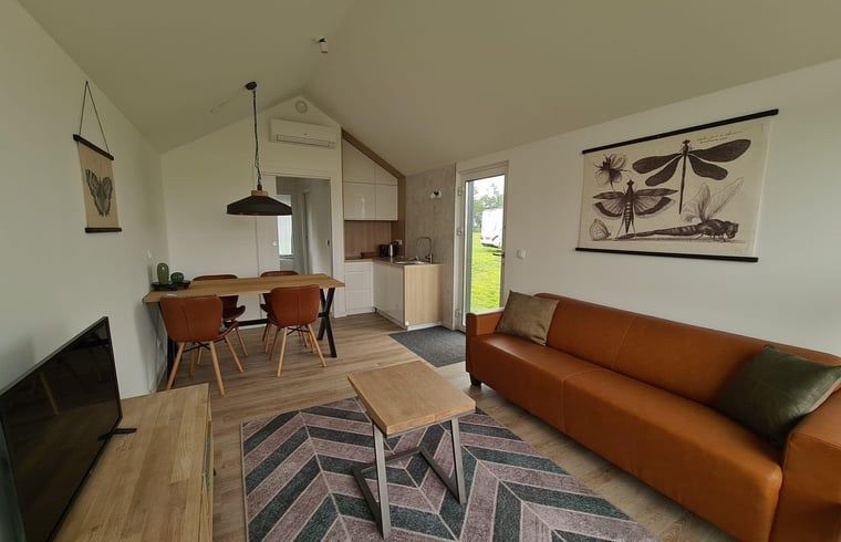 Open woonkamer en keuken in Huisje in Oudega, vakantiehuis met comfortabele faciliteiten.