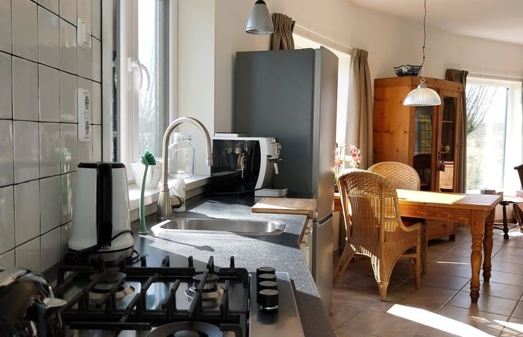 Ruime eetkamer in Vakantiehuisje in Oudega, gelegen aan het Heegermeer in de Friese meren, met grote ramen.