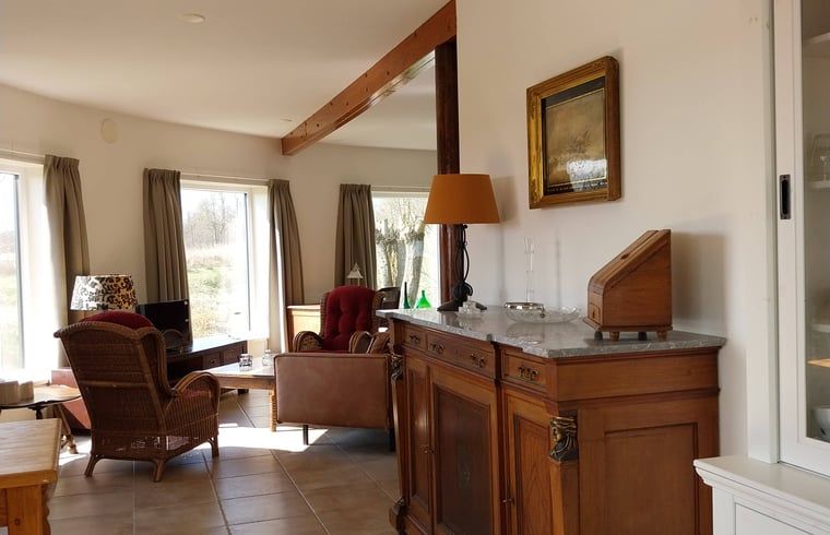 Gezellige leeshoek in Vakantiehuisje in Oudega, gelegen aan het Heegermeer in de Friese meren, met boekenkast.