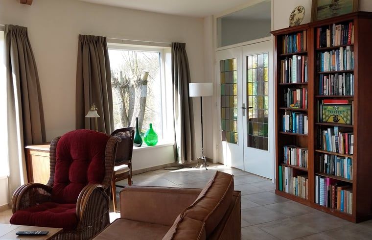 Stijlvolle zitkamer in Vakantiehuisje in Oudega, gelegen aan het Heegermeer in de Friese meren, met retro meubels.