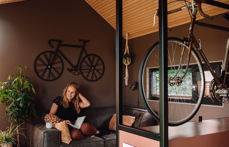 Gemuetliches Wohnzimmer im Ferienhaus in Koudum mit Fahrraddekoration und bequemen Sitzgelegenheiten.